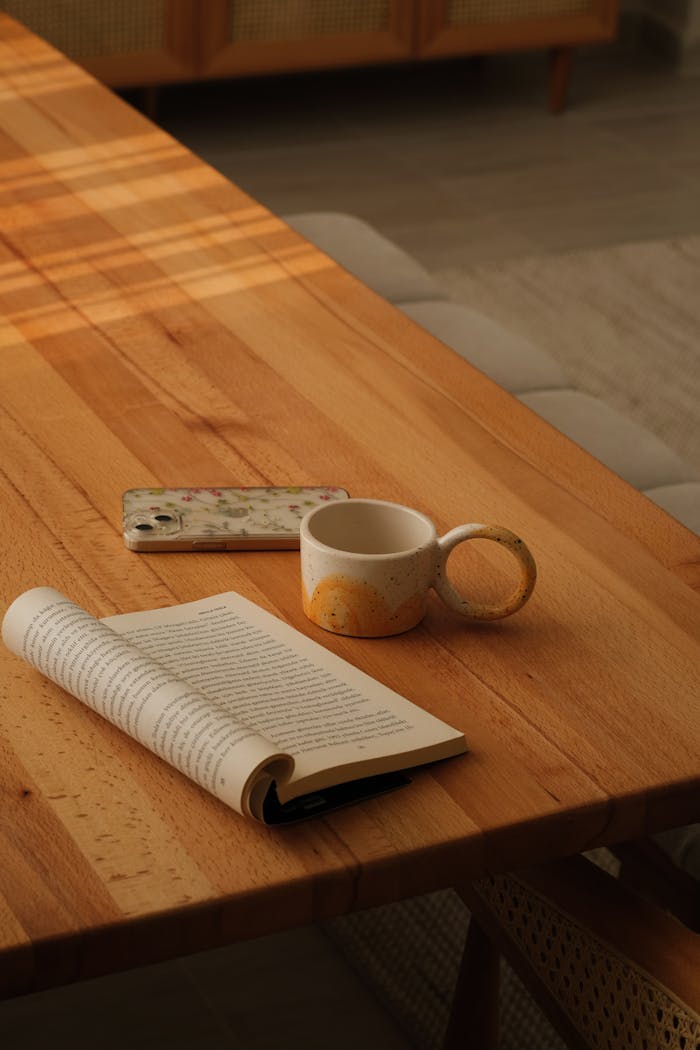 Services Warm and inviting setting with a book, mug, and phone on a wooden table, perfect for relaxation.